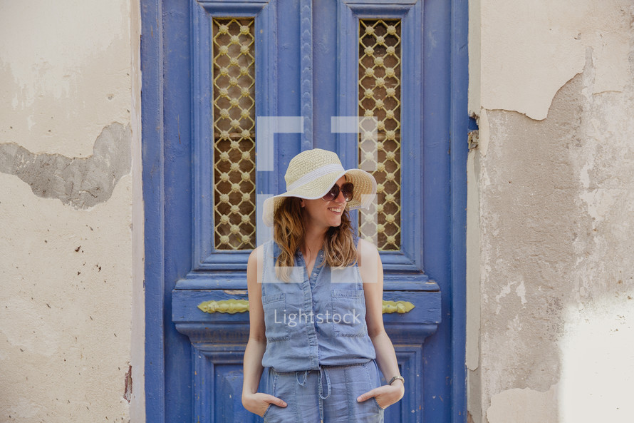 woman standing in front of a blue door in Greece 