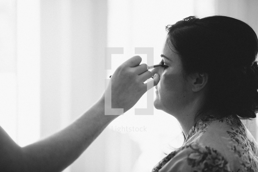 woman putting on makeup 