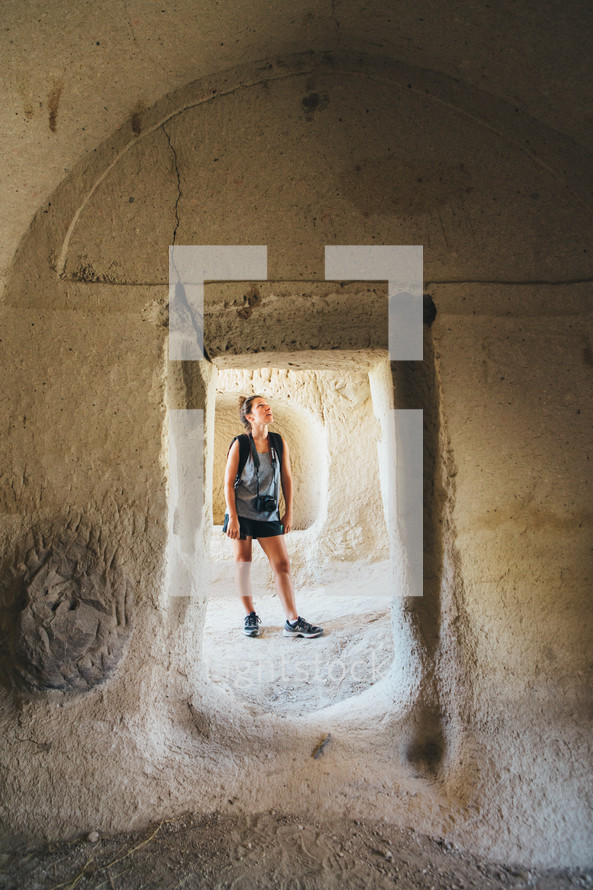 a woman exploring an ancient cave