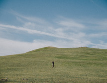 man standing on a slope with outstretched arms 