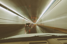 Photo of car driving through New York tunnel showing motion blur.