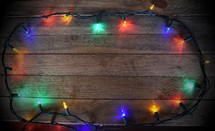 Border of Christmas Lights on wooden background (Dark Vignette)