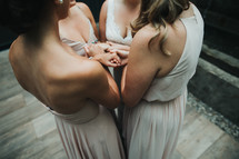 bridesmaids and bride holding hands in prayer 