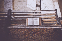 opened Bible on a bench 