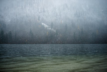 snow falling over a lake 