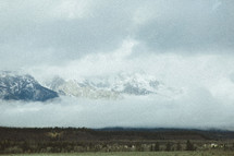 fog and low hanging clouds and a mountain peak 