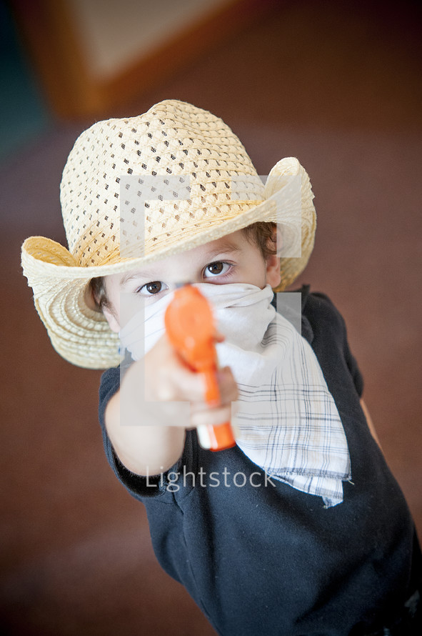 toddler pointing a toy gun 