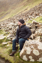 man sitting on rocks in Northern Ireland 