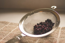 Cranberries in a strainer.