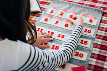 a woman stuffing an Advent calendar 
