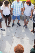 holding hands in prayer at an outdoor summer party 