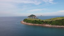 Drone view of islands in Hong Kong. Golf course aerial shot. Blue sea and green trees and grass.	
