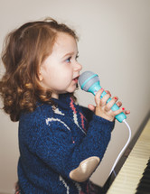 child singing into a microphone 