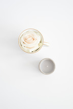 a rose in a cup and candle 