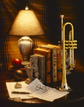 brass trumpet and papers on a table 