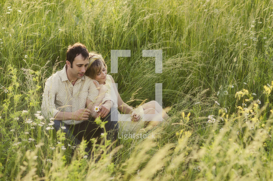 Happy couple sitting in grass field
