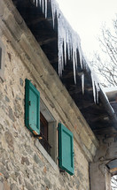 icicles on a the roof of a house 