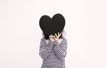 a girl holding up a heart 