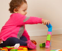 baby girl playing with toy blocks 