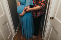 expecting couple in a hallway 