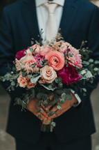 groom holding a bouquet 