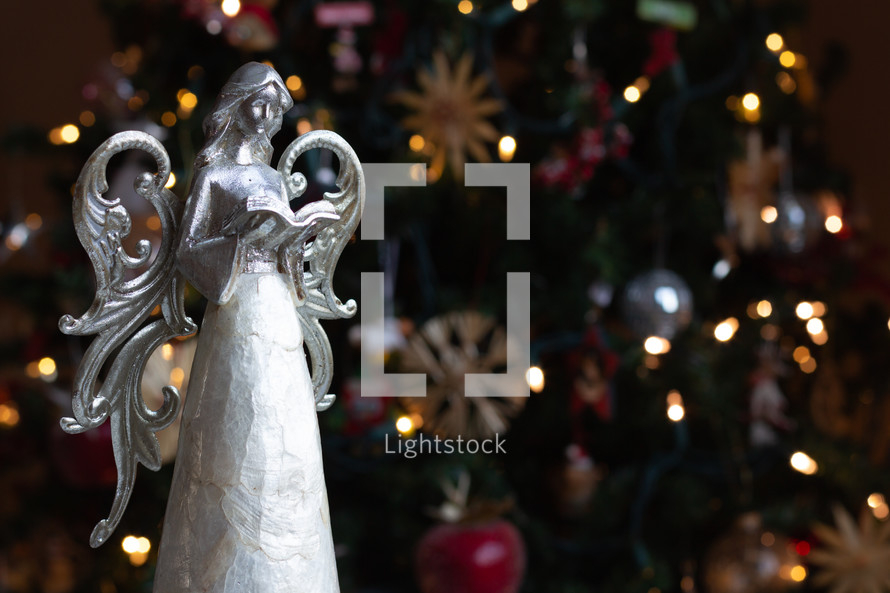 Christmas angel figurine in front of a Christmas tree 