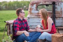 a couple sitting in the tailgate of a truck on a date