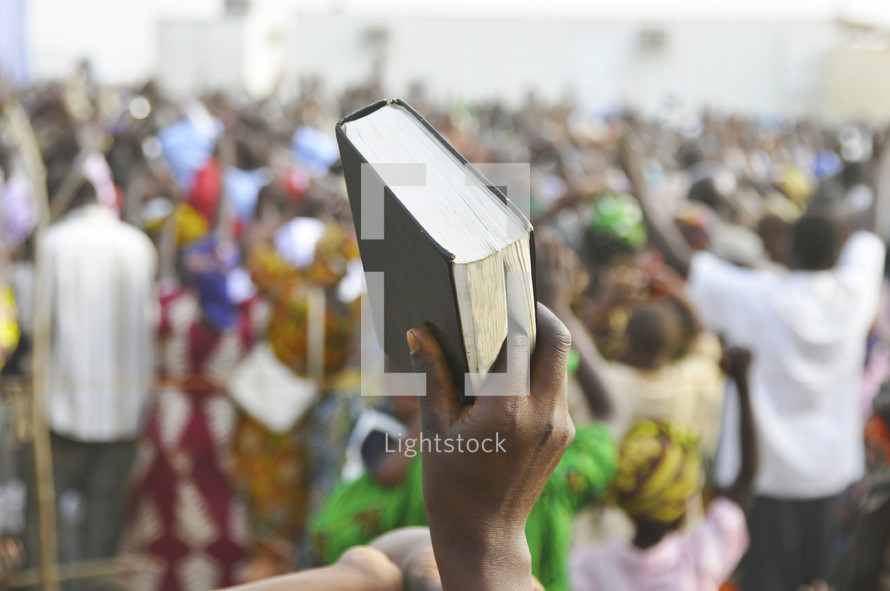 A Bible is held up high during a praise and worship service in Africa