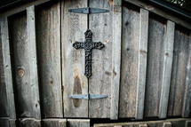 Natural wood boards display a metal cross