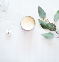 earbuds, candle, twig with leaves