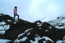 A woman hiking up a snowy mountain