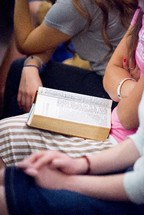 Bibles in laps during a worship service 