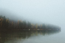 fog over a lake shore 