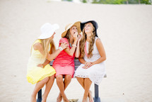 friends sitting on a bench on a beach 