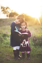 sisters hugging reading a Bible 