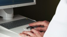 A dentist looking at a computer screen at digital scans of teeth 