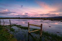 fence in a flooded field at sunset. Humboldt County, California.