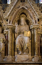 Statue of Jesus wearing a crown and sitting on a thrown 