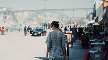 a woman walking on a sidewalk downtown 