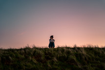 a woman sitting alone in a field 