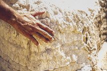 a man placing his hand on a sacred rock 
