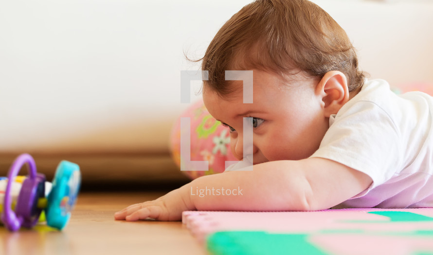 Toddler plays on the colored rubber mat