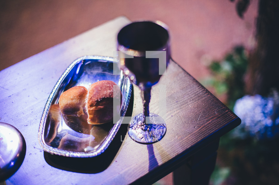 communion bread and wine in silver chalice and tray