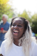 headshot of an African American woman at an outdoors summer party 