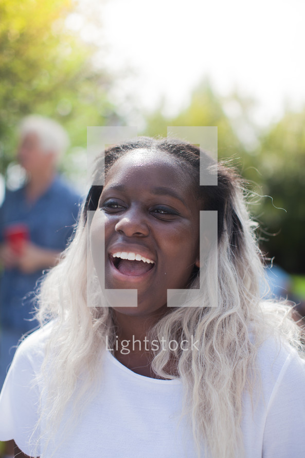 headshot of an African American woman at an outdoors summer party 
