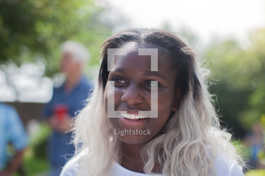 headshot of a young woman at an outdoor summer party 
