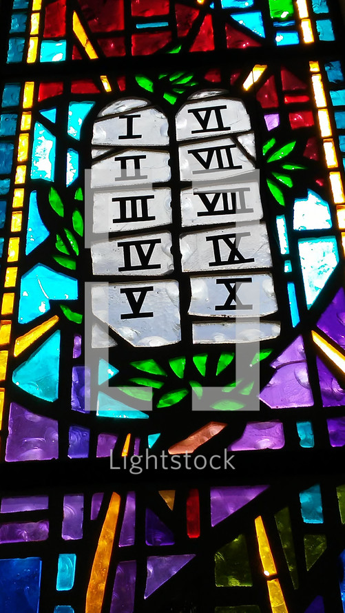 The Ten Commandments stained glass window church window showing the scrolls that make up the ten commandments that God gave to Moses and the children of Israel on Mount Sinai during the Exodus from Egypt. Beautiful stained glass artwork located in Mount Dora, Florida. 