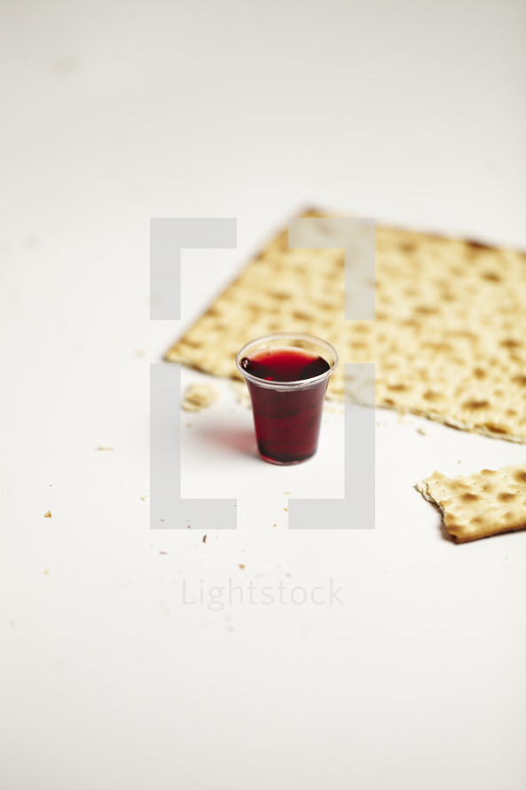 A communion cup and broken cracker isolated on white