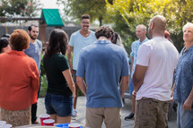 friends gathered to pray at an outdoor summer party 