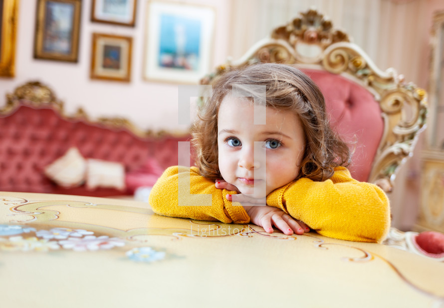 Portrait of girl toddler in a living room with baroque decor.